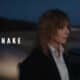 Mylène Farmer et DJ Snake réunis devant une voiture au crépuscule pour le clip Combien pour la nuit réalisé par Gilles Lellouche